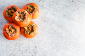 Ripe Fuyu Persimmon Isolated on Light Background, Top View with Copy Space