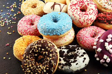 assorted donuts with chocolate frosted, pink glazed and sprinkles donuts