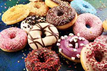 assorted donuts with chocolate frosted, pink glazed and sprinkles donuts