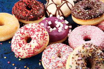assorted donuts with chocolate frosted, pink glazed and sprinkles donuts