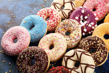 assorted donuts with chocolate frosted, pink glazed and sprinkles donuts