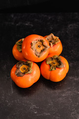 Ripe Fuyu Persimmon Isolated on Dark Background, Closeup Top View