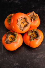Ripe Fuyu Persimmon Isolated on Dark Background, Closeup