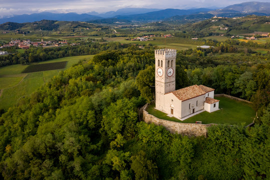 Aerial view of secluded church on top of forested hill