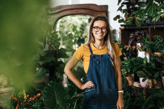 Portrait of a happy young woman in a small gardening shop