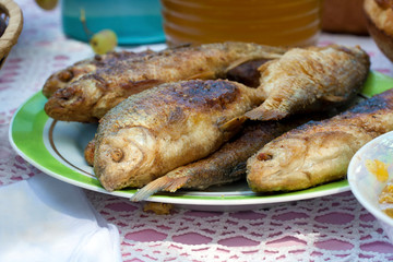 Fresh fried whole fishes on the plate in open air picknick
