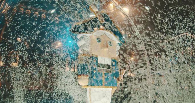 Figurine of a nutcracker in a transparent bowl with snow.