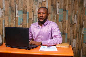 Young black businessman sitting in his office and working on some documents on his desk