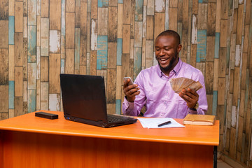 Young black businessman sitting in his office and working on some documents on his desk