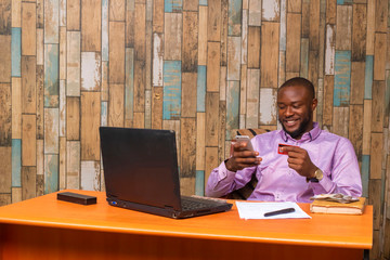 Young black businessman sitting in his office and working on some documents on his desk