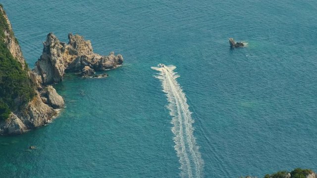 View from above on Paleokastritsa bay in a sunny day, Corfu island, Greece. Motor Boat Moving. ProRes 422HQ 10 Bit mov.