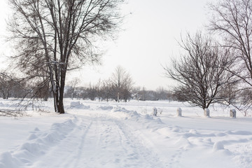 Winter poorly cleared road. Road in the countryside strewn with snow. Winter landscape with snowdrifts