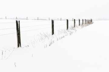 Fence in Snow Covered Field in Winter