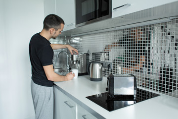 Guy prepare delicious aromatic coffee in a coffee machine. A simple way to make coffee