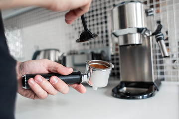 Fototapeta na wymiar Guy prepare delicious aromatic coffee in a coffee machine. A simple way to make coffee
