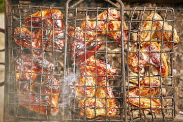 Fried food. Barbecue chicken grill, smoke goes through the meat on the grill.
