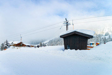 Chalet house of Zillertal Arena ski resort in Tyrol in Mayrhofen in Austria in winter Alps. Alpine mountains with white snow and blue sky. Downhill peaks at Austrian snowy slopes.