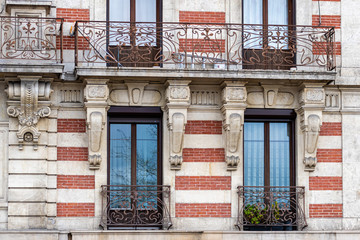 Fototapeta na wymiar Facade of a historic brick building with metal balconies. Geneva, Switzerland