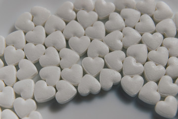 Fototapeta na wymiar Tablets. Candies. Heart shaped pills. A lot of little hearts.