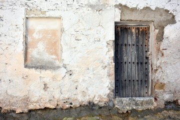 Fachadda de una antigua casa con puerta vieja de madera