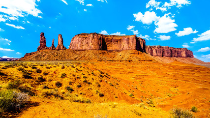 The towering red sandstone formations of the Three Sisters pinnacles and Mitchell Mesa in Monument Valley Navajo Tribal Park desert landscape on the border of Arizona and Utah, United States