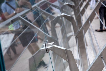 steel fastenings of protective glass on the construction of the pedestrian bridge close up.