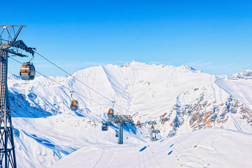 Cable cars at Hintertux Glacier ski resort in Tyrol in Mayrhofen in Zillertal valley, Austria in winter Alps. Chair lifts in Hintertuxer Gletscher in Alpine mountains with white snow and blue sky.