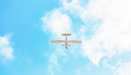 Fototapeta na wymiar A small pleasure plane flying in the blue sky