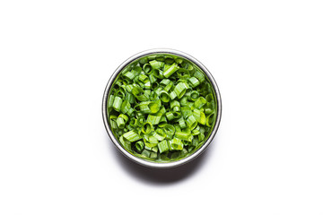 Chopped Chives garnish in stainless steel bowl, top down view isolated on a white background with drop shadow.