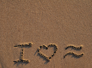 Symbols I love sea written on sand. Summertime concept.