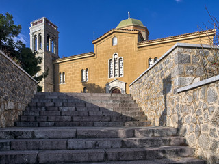 Arahova, Parnassos, Greece, stone steps lead to Agios Georgios (Saint George) church under deep blue sky.