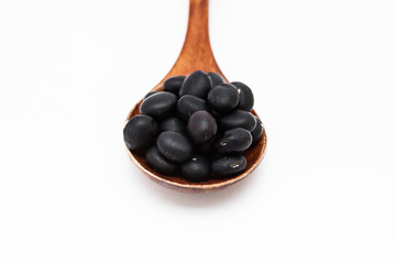 Black bean grains spoon on a white
