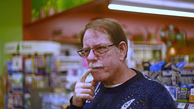 Man plays funny character by making goofy faces and gestures in store