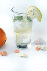 Glass of water with lemon, mint and with diet supplements