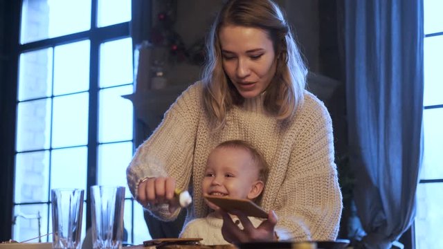 Mom And Son Collect A Gingerbread House In A Dark Blue Kitchen