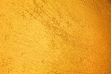 Bright gold paint concrete wall old surface or yellow colorful background