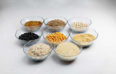 Legumes in glass containers on a table like corn, lentil, rice, oatmeal, beans and quinoa