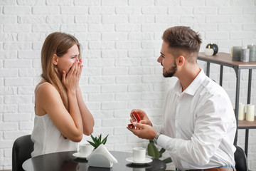 Young man proposing to his beloved on romantic date