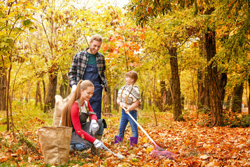 Family cleaning up autumn leaves outdoors