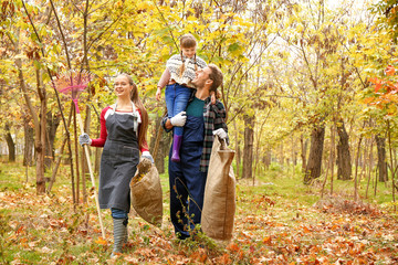 Family cleaning up autumn leaves outdoors