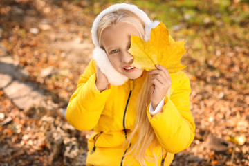 Cute little girl with leaf in autumn park