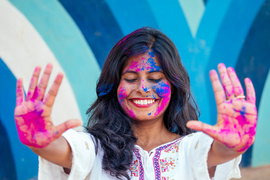 Holi Festival Of Colours. Portrait of happy indian girl in holi color. snow white smile and perfect hairstyle