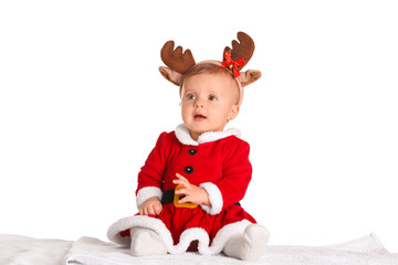 Cute little baby in Santa Claus costume and deer horns on white background