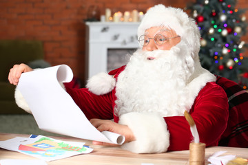 Santa Claus reading wish list in room decorated for Christmas