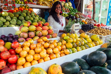 smiling indonesian business woman in kerala goa sell fruit and vegetable farm