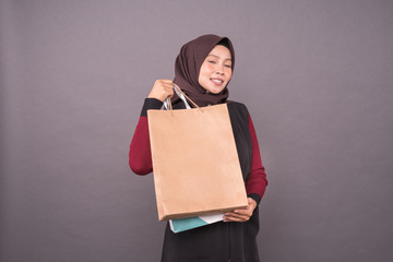 Happy malay girl holding shopping bags.