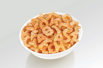 Fried and Spicy ABCD, Alphabet Snacks or Fryums (Snacks Pellets) served in a white bowl. selective focus - Image