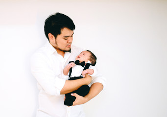 Asian Father hug baby son in his arm at home.