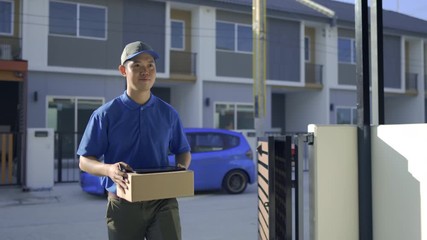 Delivery man sending parcel postal package order comes to customer at front house the open doorway, Delivery package service his smiling happy. Shot on 4K UHD Footage cinematic 