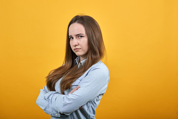 Unhappy attractive caucasian lady wearing fashion shirt isolated on orange background in studio...